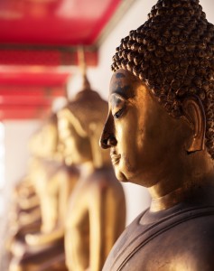 A hazy view of Buddha statues in a temple with a red ceiling