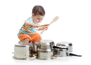 little kid boy drumming on kitchen pots